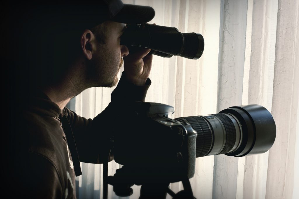 Lauth Investigations International | Private Investigators Buy Peace of Mind in Child Custody Cases man with binoculars and camera control someone